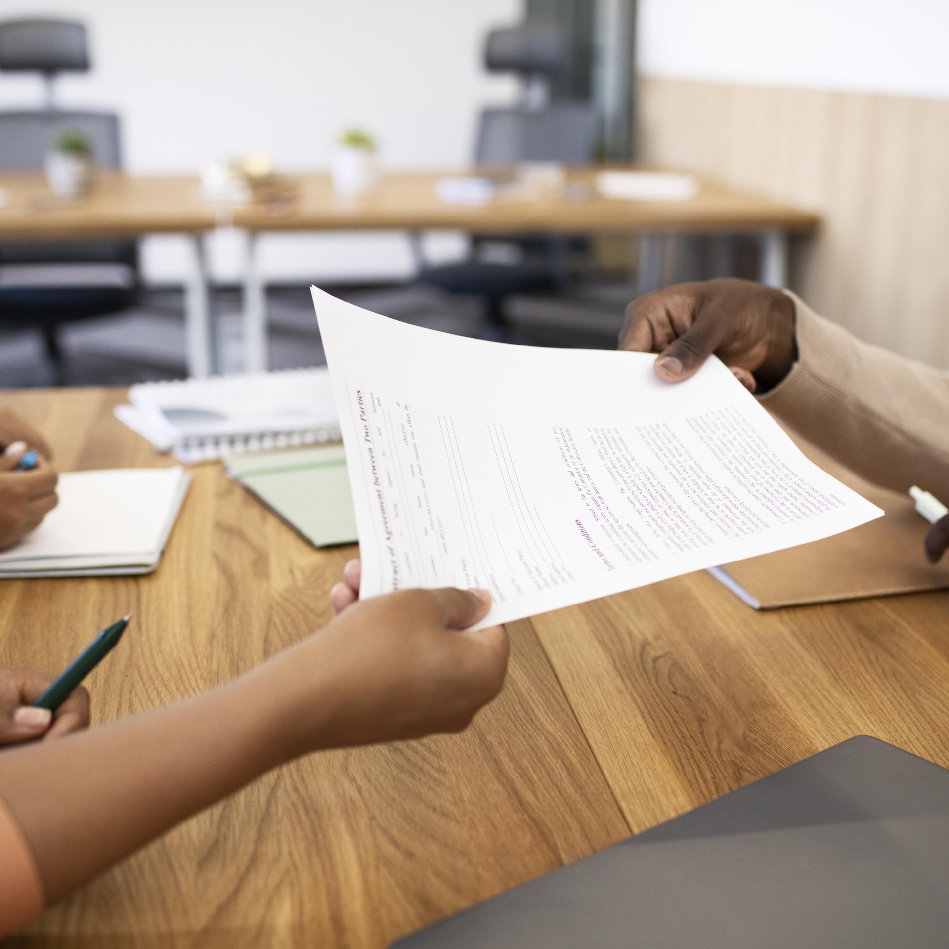 Bras d'une femme qui tend un contrat de travail à un salarié en CDI