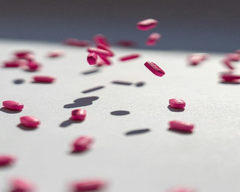 Médicaments roses fond gris et blanc